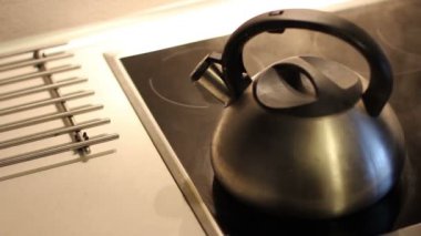 Gümüş Kettle elektrikli ocağın üzerinde kaynıyor. Buhar düdüğü ile gider.