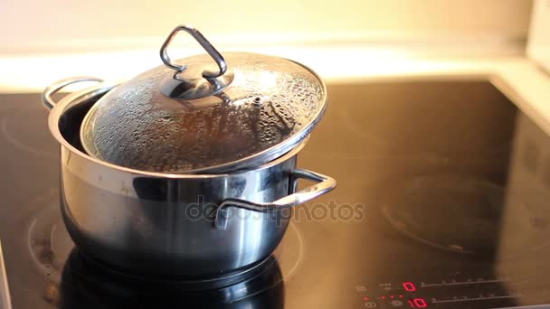 平底锅在烹饪盘上 荞麦粥是在锅里煮的 壶里的水沸腾冒泡 — 图库视频影像