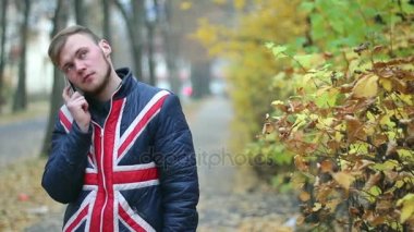 genç adam cep telefonu duran sarı çalı yakınındaki konuşurken