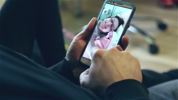 Vater Schaut Sich Fotos Von Neugeborenem Und Seiner Frau — Stockvideo