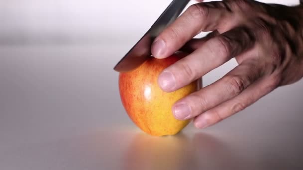 ナイフで男性の手は リンゴを半分に切る アップルは つの半分に分かれています 黄色リンゴの赤い辺 — ストック動画