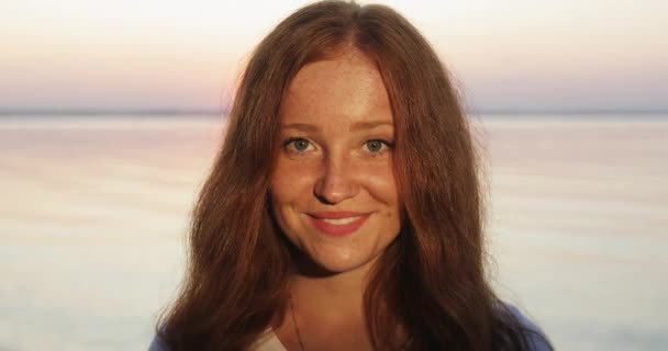 Portré fiatal boldog nő piros göndör haj néz a kamera mosolygó. — Stock videók
