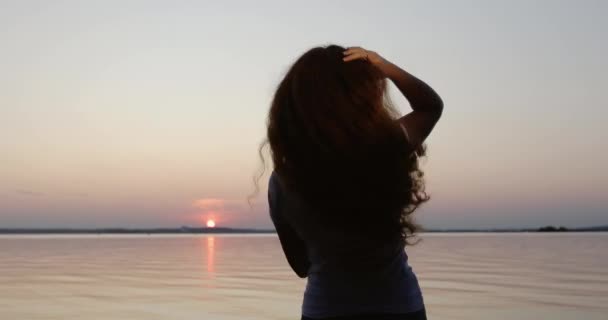 Une jeune femme danse au coucher du soleil . — Video