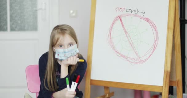 Hou Covid-19 tegen. Het meisje tekende een virus op een tekentafel. Kind geïsoleerd thuis. — Stockvideo