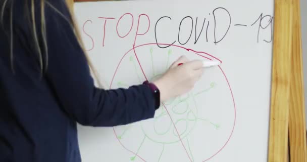 Un bambino disegna un virus su un tavolo da disegno. Ragazza ha scritto una fermata Covid-19 . — Video Stock