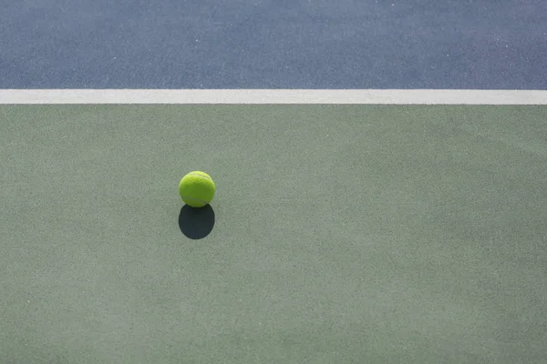 Balle de tennis sur le terrain dur bleu et vert divisé par une ligne blanche — Photo