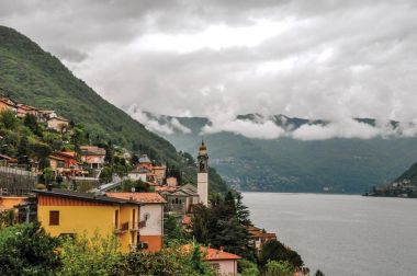 Como Gölü kıyısında dağlar ve bulutlu yağmurlu bir gün köylerde ile genel bakış.