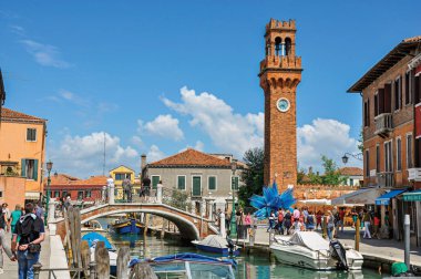 İnsanlar, binalar ve saat kulesi önünde canal Murano adlı görünümünü