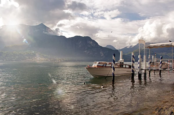 Utsikt över Comosjön i en molnig dag med motorbåt och hamnen i Bellagio — Stockfoto