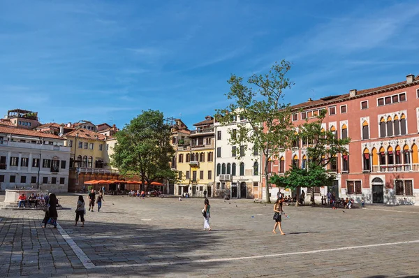 Square view of colorful old buildings, restaurants and people