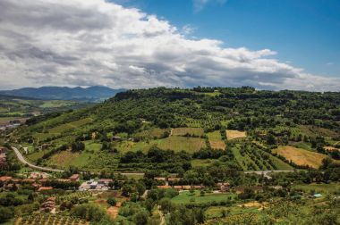 Yeşil tepeler, üzüm bağları ve şehir rooftops bir road yakınındaki genel bakış.