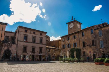 Eski binalar, Saat Kulesi, dükkanı ve Orvieto güneşli gökyüzü ile kare