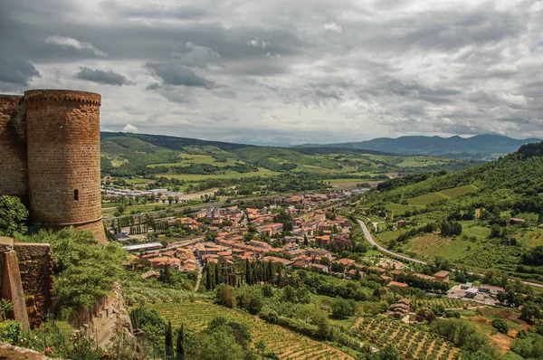 Overview of stone tower, green hills, vineyards and town rooftops near a road. — Stock Photo, Image