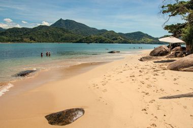 View of beach, sea and forest on sunny day in Ilha do Pelado, a tropical beach near Paraty clipart