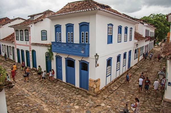 View of people in alley with stone sidewalk and old houses on cloudy day in Paraty — Stock Photo, Image