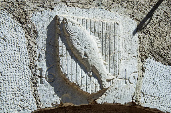 Escudo heráldico esculpido em pedra com peixe e data no centro histórico da cidade de Annecy — Fotografia de Stock