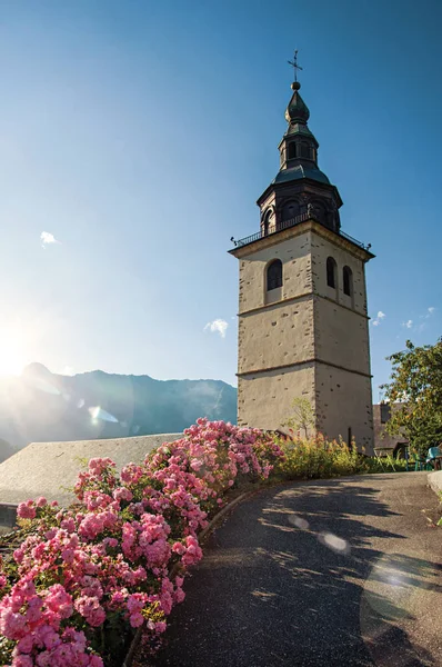 View of church steeple and flowers in the medieval village of Conflans, near the town of Albertville — Stock Photo, Image