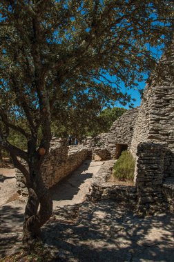 Yol ve Bories köy içinde güneşli mavi gökyüzü altında taştan yapılmış kulübe Gordes kasaba yakınlarında.