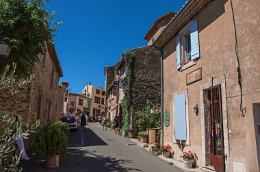 Traditional stone houses on a street of the historical and lovely city center of Gordes clipart
