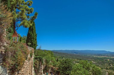 Görünüm alanları ve Provence yakınındaki Gordes, tepeler güneşli mavi gökyüzü altında.