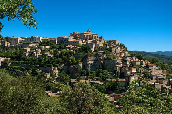 Vista panorámica del pueblo de Gordes en la cima de una colina y bajo el soleado cielo azul . —  Fotos de Stock