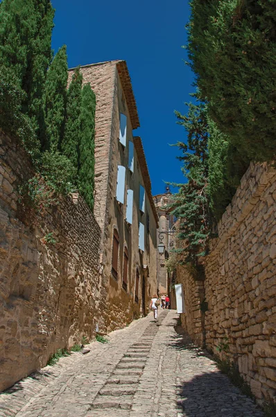 Tipiche case in pietra con cielo azzurro soleggiato, in un vicolo del centro storico di Gordes . — Foto Stock