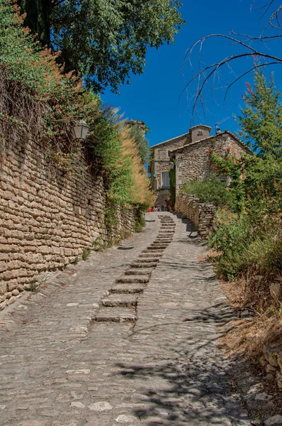 Vista de las típicas casas de piedra con cielo azul soleado, en un callejón del centro histórico de Gordes . — Foto de Stock