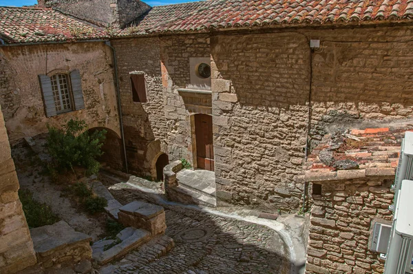 Vista de las típicas casas de piedra con cielo azul soleado, en un callejón del centro histórico de Gordes . —  Fotos de Stock