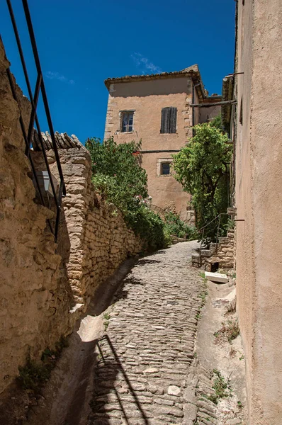 Tipik taş evleri ve tarihi şehir merkezi Gordes sokakta güneşli mavi gökyüzü ile duvar görünümü.