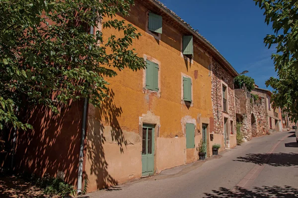 Traditional colorful houses in ocher and blue sky in the historic city center of Roussillon. — Stock Photo, Image