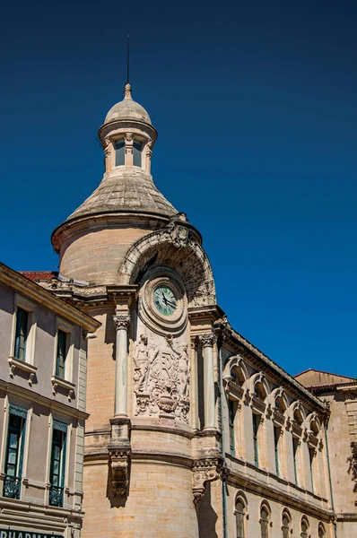 Primer plano de los edificios en el centro de la ciudad de Nimes, con reloj, columnas, detalles decorativos en las paredes — Foto de Stock