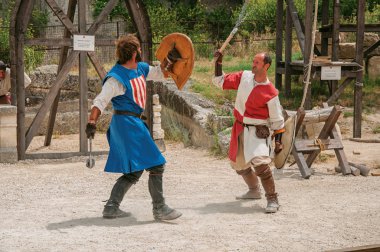 Actors doing a theatrical staging as medieval fighters in the castle of Baux-de-Provence. clipart