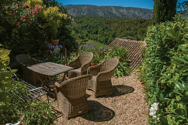 Vista del pequeño jardín con montañas y el cielo azul soleado en el fondo, en el pueblo de Menerbes . — Foto de Stock