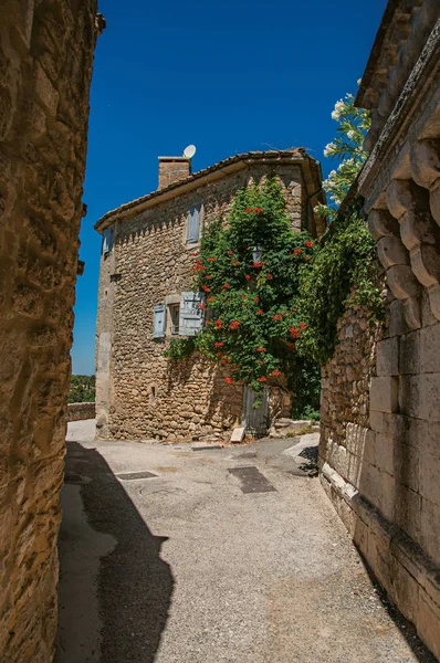 Pohled na typické kamenné domy s sunny modrá obloha, v uličce historické vesnice Menerbes. — Stock fotografie