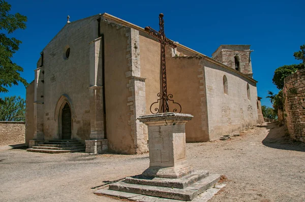 Menerbes の歴史的な村で、前景で晴れた日に石造りの教会の正面のクルーズします。. — ストック写真