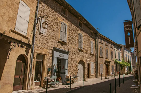 Vista de casas de pedra típicas e lojas em uma rua da aldeia histórica de Lourmarin . — Fotografia de Stock