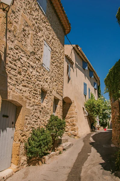 Weergave van typische stenen huizen met zonnige blauwe hemel, in een verhoogde steegje van het historische dorp van Lourmarin. — Stockfoto