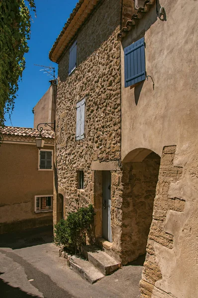 Weergave van typische stenen huizen met zonnige blauwe hemel, in een verhoogde steegje van het historische dorp van Lourmarin. — Stockfoto