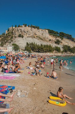  Yıkananlara Cassis arka planda kalede ile çakıl plaj.