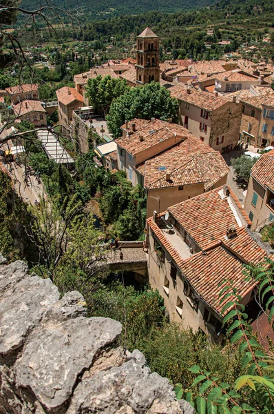 Vista de árboles, techos de casas y campanario bajo el soleado cielo azul en el encantador pueblo de Moustiers-Sainte-Marie . —  Fotos de Stock