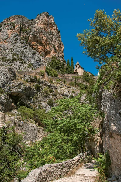 Veduta della chiesa di Notre-Dame de Beauvoir tra scogliere e scalinate rocciose, sopra il grazioso villaggio Moustiers-Sainte-Marie . — Foto Stock