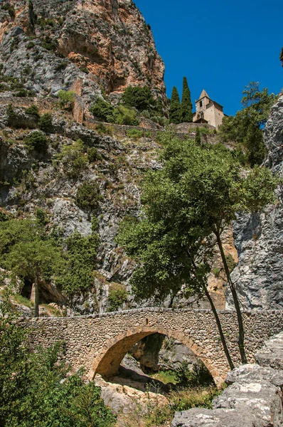 Notre-Dame de Beauvoir kilisenin ortasında kayalıklarla ve zarif Moustiers-Sainte-Marie Köyü yukarıda kaya köprü görünümü. — Stok fotoğraf
