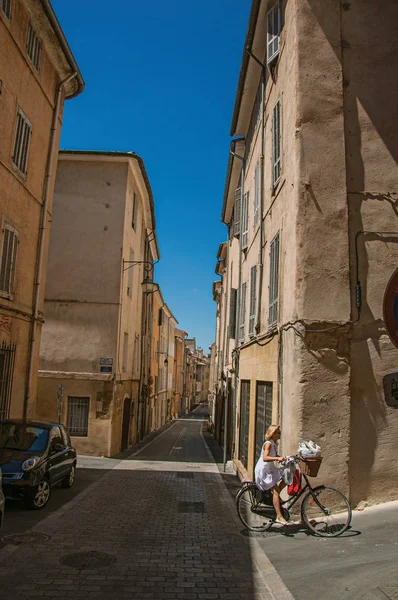 Mujer en bicicleta en los callejones de Aix-en-Provence, una ciudad agradable y animada en la campiña francesa . — Foto de Stock