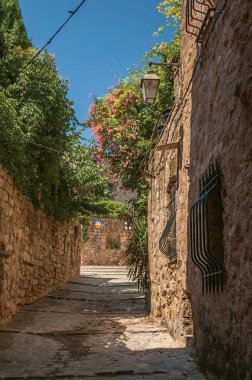 Mavi gökyüzü, Les Arcs-sur-Argens adlı altında dar bir sokakta görünümü taş evler.