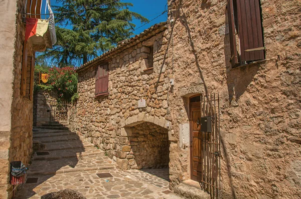 View of stone houses in a narrow alley under blue sky, at Les Arcs-sur-Argens. — Stock Photo, Image