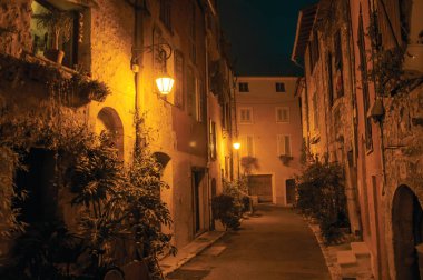 Night view of alley with walls and stone houses in the village of Vence. clipart
