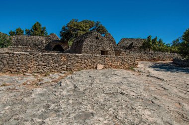 Taş duvarlı çit ve güneşli mavi gökyüzünde, Gordes yakınındaki Bories köyü ile yapılan tipik kulübe Panoraması. Vaucluse bölümü, Provence bölgesini, Güneydoğu Fransa