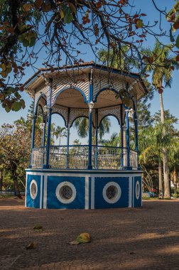 Bahçe dolu yemyeşil ağaçlarda Sao Manuel, güneşli bir gün ortasında eski bir renkli çardak close-up. Sao Paulo eyalet kırsal kesimde şirin bir kasaba. Güneydoğu Brezilya.