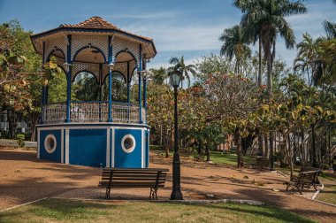 Eski renkli gazebo ve aydınlatma direği Bahçe dolu yemyeşil ağaçlarda Sao Manuel, güneşli bir gün ortasında. Sao Paulo eyalet kırsal kesimde şirin bir kasaba. Güneydoğu Brezilya.