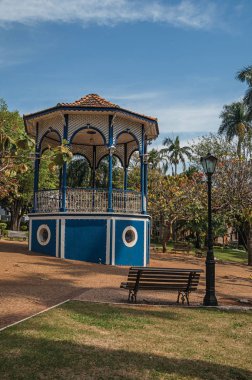 Eski renkli gazebo ve aydınlatma direği ile Sao Manuel, güneşli bir günde yeşil çim Bahçe ortasında. Sao Paulo eyalet kırsal kesimde şirin bir kasaba. Güneydoğu Brezilya.